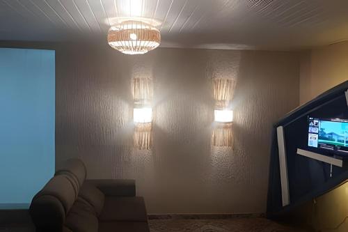 een woonkamer met een bank, een tv en verlichting bij Sonho do Mar in Antonina
