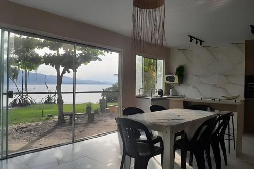 een keuken met een tafel en stoelen en een groot raam bij Sonho do Mar in Antonina