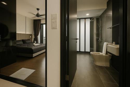 a bathroom with a toilet and a bed in a room at Alma's Suites Luna Studio 2Pax Puteri Harbour by Our Stay in Iskandar Puteri