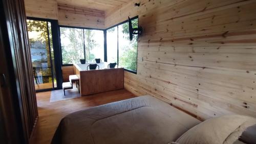 a room with a wooden wall with a couch and a desk at La Cabaña de Jofiel in Supatá