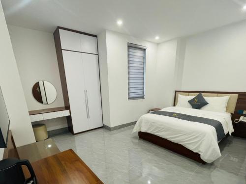 a bedroom with a large bed and a window at Tâm Khang Hotel in Móng Cái