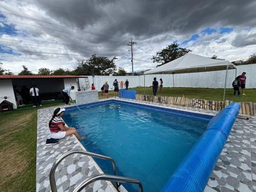 una mujer está sentada junto a una piscina en Entire house with a pool for total relaxation!, 