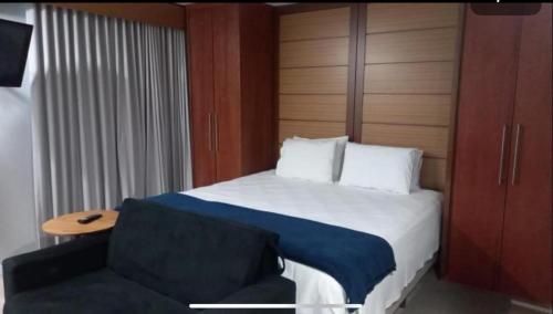 ein Hotelzimmer mit einem Bett und einem Stuhl in der Unterkunft Aparthotel Av Ibirapuera Moema Congonhas in São Paulo