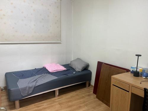 - un petit lit dans une chambre avec une table dans l'établissement Young Place, à Songt'an