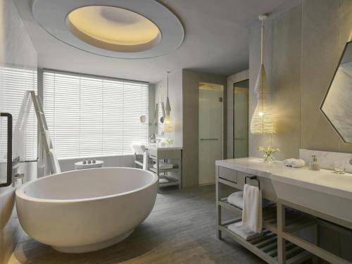 baño grande con bañera grande y lavamanos en Mövenpick Siam Hotel Na Jomtien Pattaya, en Na Jomtien
