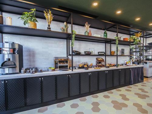 un restaurante cocina con encimera y fogones en Ibis Styles Rouen Centre Rive Gauche, en Rouen