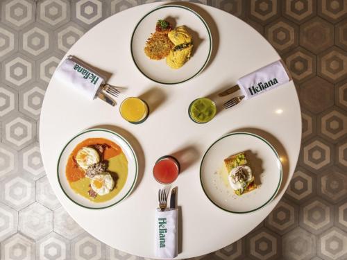 メキシコシティにあるNovotel Mexico City Toreoの3枚の皿に食べ物が載った白い皿