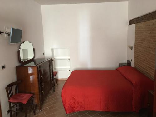 a bedroom with a red bed and a dresser at Guest House Dimora Fiorita in Serracapriola