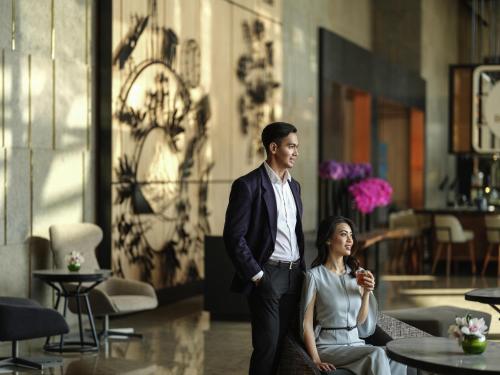 a man and a woman standing in a room at Swissôtel Jakarta PIK Avenue in Jakarta