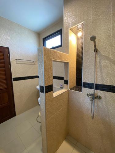 a bathroom with a shower with a glass door at YES Apartments in Ban Saiyuan (1)