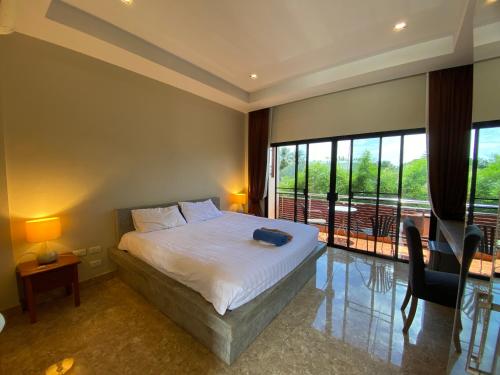 a bedroom with a large bed and a balcony at YES Apartments in Ban Saiyuan (1)