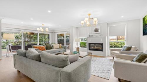 a living room with couches and a fireplace at Holiday Retreat in Pokolbin