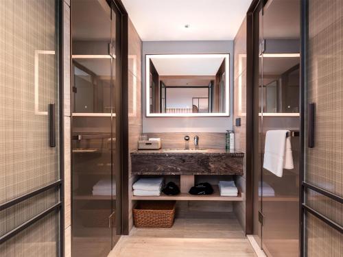 a bathroom with a sink and a mirror at Hilton Garden Inn Zhoushan Mount Putuo in Zhoushan