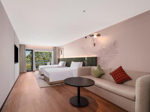a living room with a white couch and a table at Hilton Garden Inn Zhoushan Mount Putuo in Zhoushan