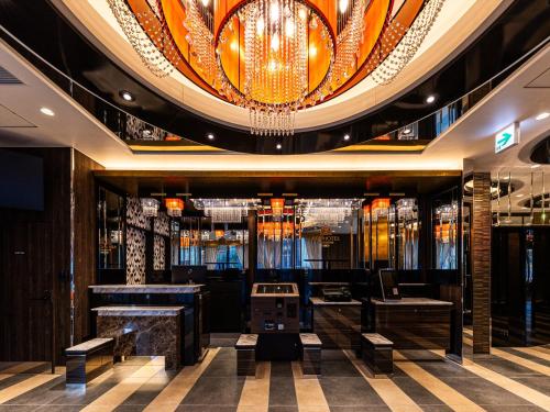 a lobby with a large chandelier in a building at APA Hotel Tottori Ekimae in Tottori