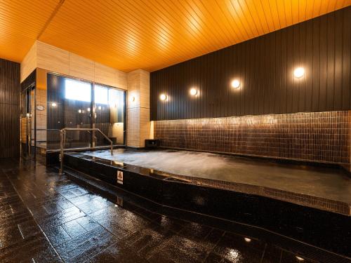 an empty swimming pool in a room with a pool at APA Hotel Tottori Ekimae in Tottori