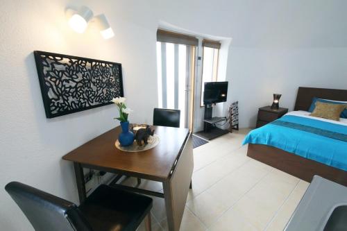 ein Schlafzimmer mit einem Bett und einem Tisch mit einer blauen Vase in der Unterkunft URUMA DOME Neptune9 in Uruma