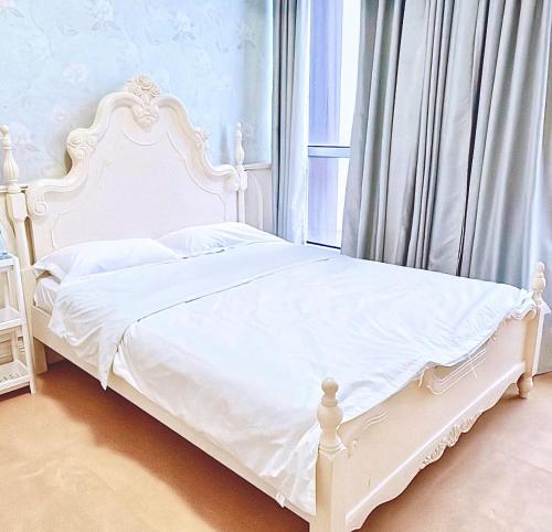a white bed in a bedroom with a window at Ding Ding Warm Home in Nanjing