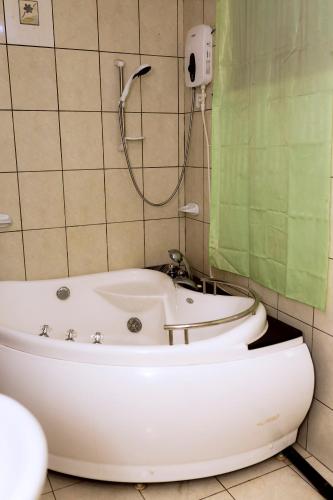 a bathroom with a bath tub and a toilet at Kivu Go-Lax Resort in Gisenyi