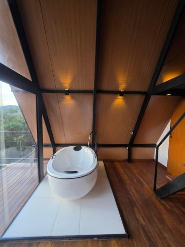 a bathroom with a toilet in a room with a window at Cabana Fé Miguel Pereira Com Ofuro e Por do Sol in Miguel Pereira