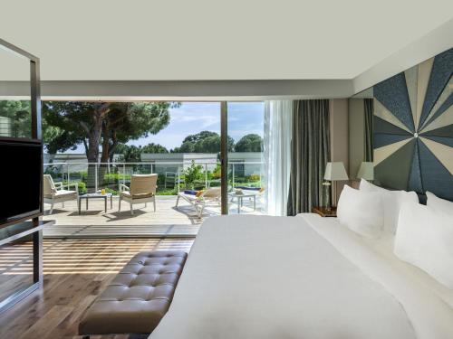 a bedroom with a large white bed and a balcony at Club Prive By Rixos Belek in Belek