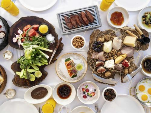 ein Tisch mit Tellern und Schüsseln voller Essen in der Unterkunft Club Prive By Rixos Belek in Belek