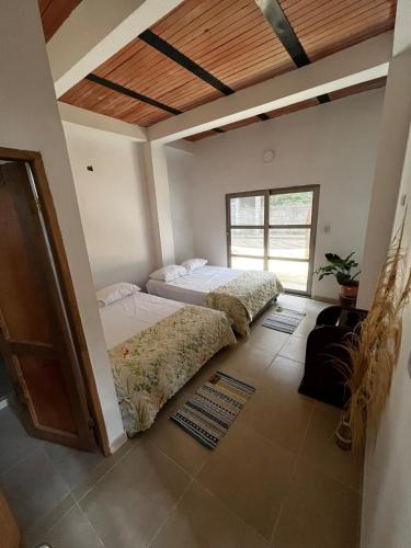 a bedroom with two beds and a wooden ceiling at Isla Rosa Coveñas in Coveñitas