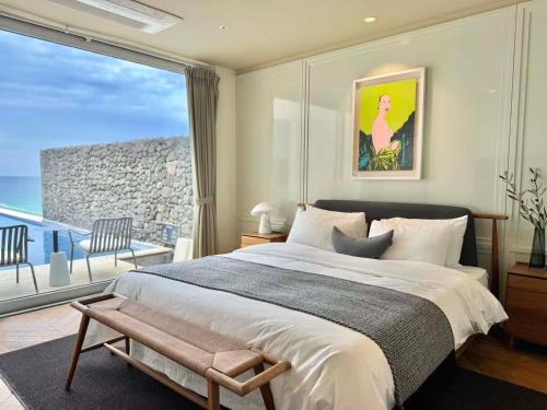 a bedroom with a large bed and a large window at Xinsu Woljeongli in Jeju