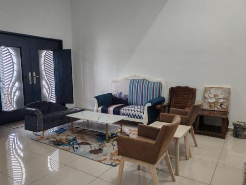 a living room with chairs and a couch and a table at Homestay Q Haven in Kuantan