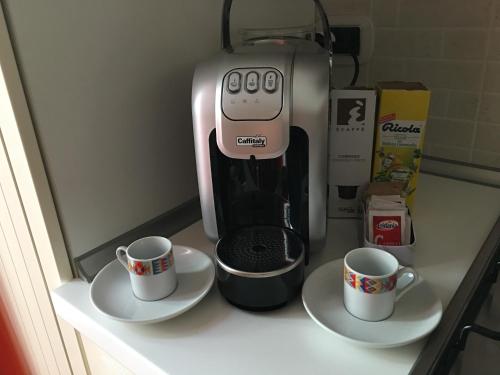 a coffee maker and two cups on a counter at Guest House Dimora Fiorita in Serracapriola