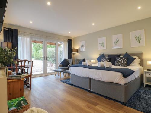 Church LeighにあるThe Lodge at Middleton Houseの大きなベッドとリビングルームのある寝室