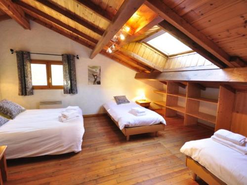 une chambre mansardée avec deux lits et une fenêtre dans l'établissement Chalet 10p avec Jardin, Proche Pistes, Wi-Fi, Cheminée - La Salle-les-Alpes - FR-1-762-49, à Le Bez