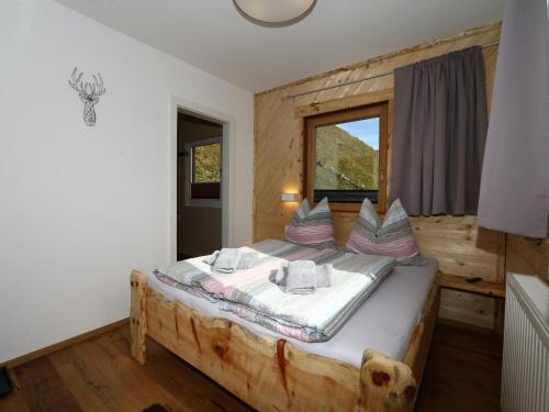 Un dormitorio con una cama grande en una habitación de madera. en Unique alpine pasture in the Zillertal mountains, en Zellberg