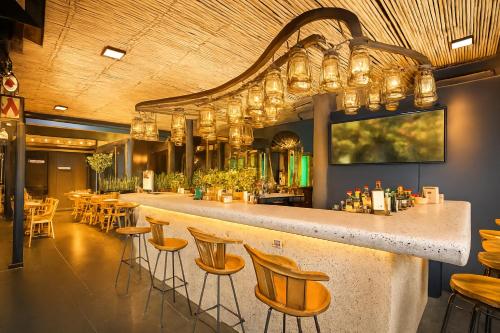 a bar in a restaurant with chairs and tables at The Bridge Residence Hotel in Kanchanaburi City
