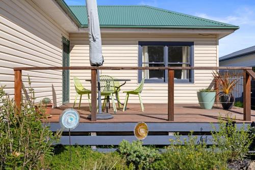 a deck with a table and chairs on a house at Vintage Sunrise in Inverloch