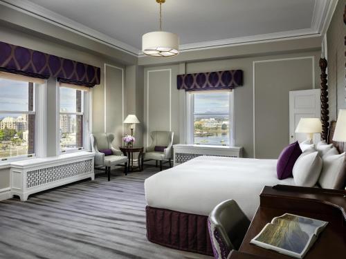 a hotel room with a large bed and windows at Fairmont Empress Hotel in Victoria