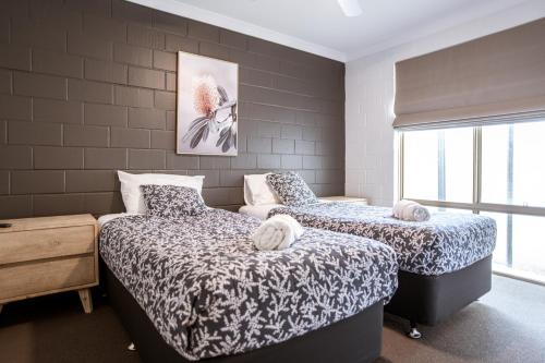 a bedroom with two beds and a window at Archipelago Apartments Esperance in Esperance