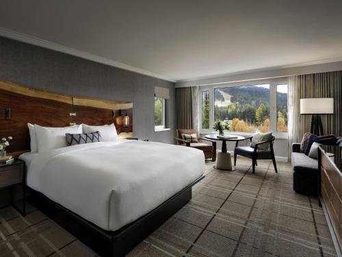 a bedroom with a large bed and a living room at Fairmont Chateau Whistler in Whistler