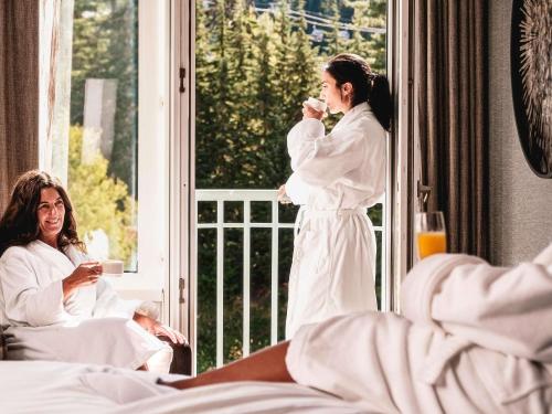 a woman brushing her teeth in front of a window at Fairmont Chateau Whistler in Whistler