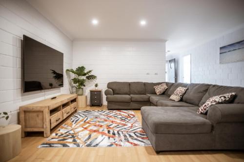 a living room with a couch and a rug at Archipelago Apartments Esperance in Esperance