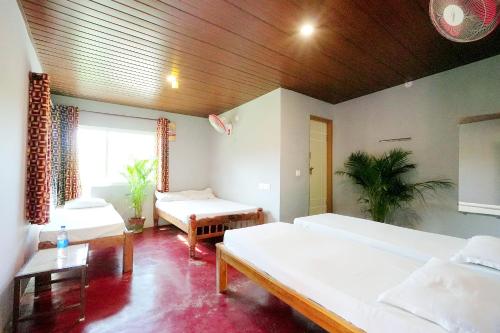 a large room with two beds and a table at Rainy Cloud Homestay 3B, Balcony, Home Food in Chikmagalūr