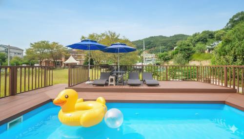 a yellow rubber duck in a swimming pool with umbrellas at Gapyeong Rialto Pension in Gapyeong