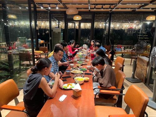 a group of people sitting at a table eating food at Son Bá Mười Ecolodge 