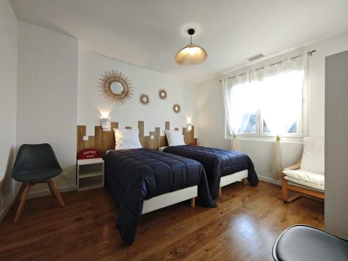 Un dormitorio con dos camas y una ventana y una silla. en Gîte Amaren Bidea, chez Simone et Manu, 