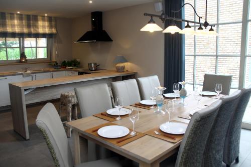 a dining room with a wooden table and chairs at Wilgenwind in Sijsele