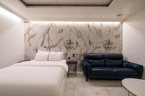 a bedroom with a bed and a couch at S Hotel in Bucheon