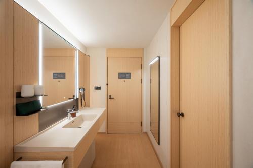 a bathroom with a sink and a mirror at JI Hotel Qingdao Haier Industrial Park Wannianquan Road Subway Station in Qingdao