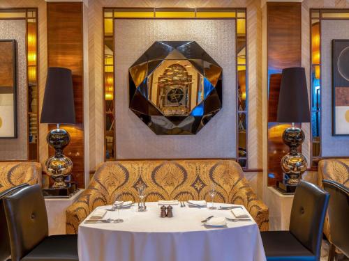 メッカにあるラッフルズ マッカ パレスの白いテーブルと椅子のあるダイニングルーム