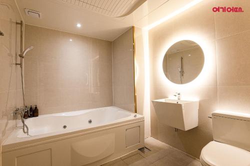 a bathroom with a tub and a toilet and a sink at S Hotel in Bucheon