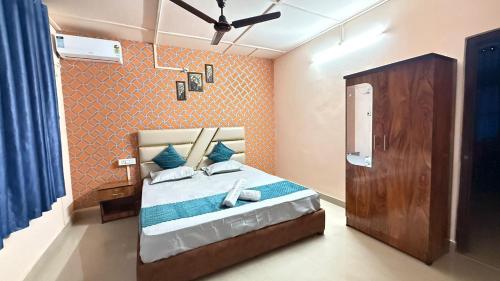 a bedroom with a bed with a blue and orange wall at Royal Palace in Dibrugarh